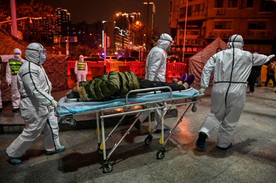 Medical staff members wearing protective clothing rush to help a patient during the pandemic outbreak in January