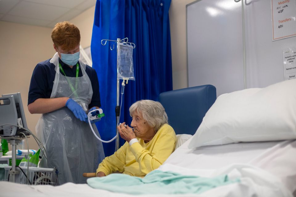 A Rehab Support Worker checks patient Shirley Hughes, 86, as she recovers from the coronavirus