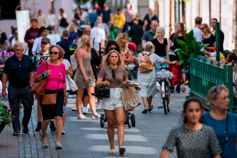 People walk without face coverings in Stockholm, during the coronavirus pandemic