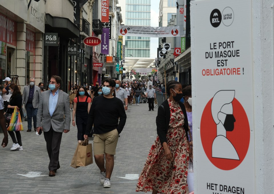 Masked shoppers in the main Shopping street of Brussels at the third day of the summer sales