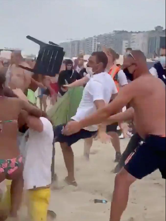 A chair is hurled across the sand at Blankenberge beach, Belgium, as sunbathers launch themselves at one another