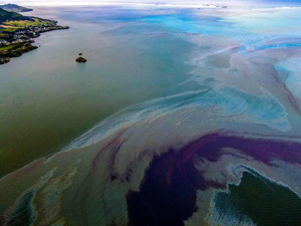 A dark oil slick spreading in the turquoise waters near the honeymoon islands