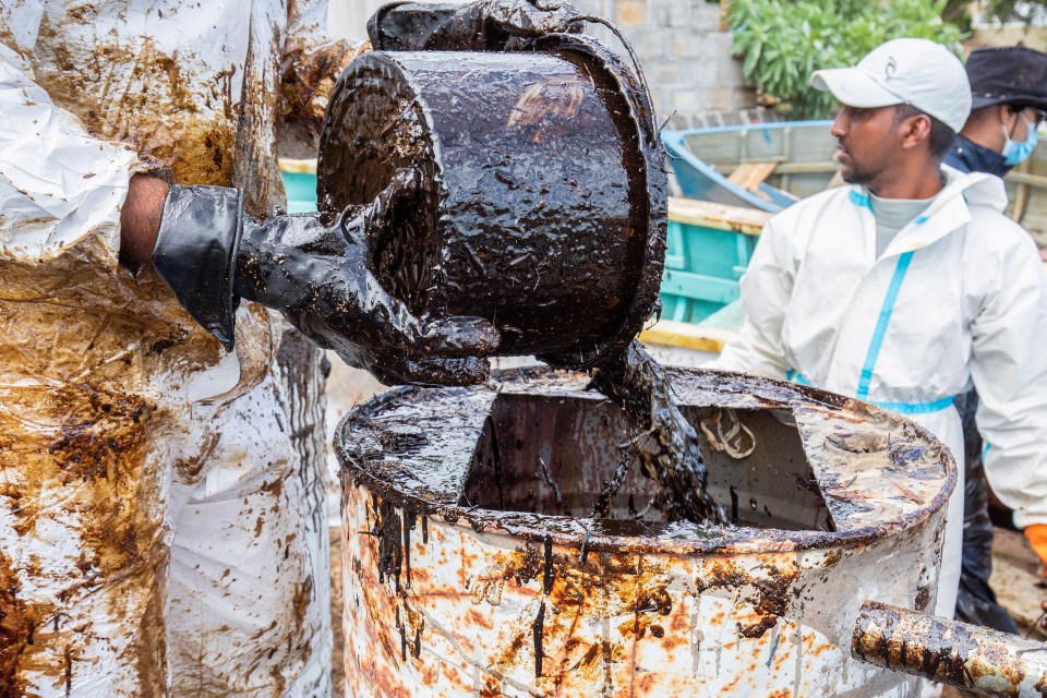 The thick gunge is being poured into barrels before being removed from the coast