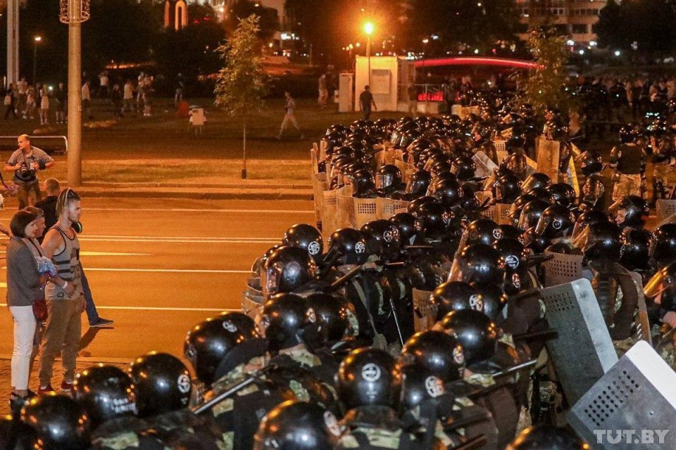 Riot police stand in a battleline against the protesters