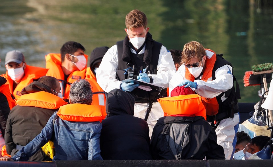 Crew attend to migrants in a Border Force boat today