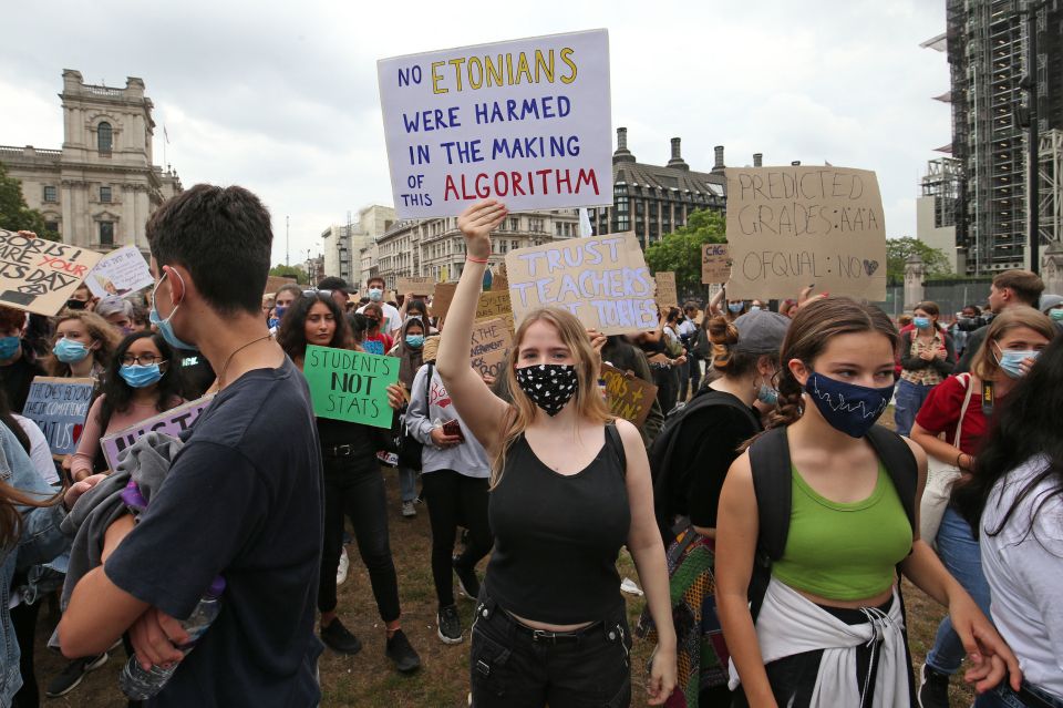 A student carries a sign reading: "No Etonians were harmed in the making of this algorithm"