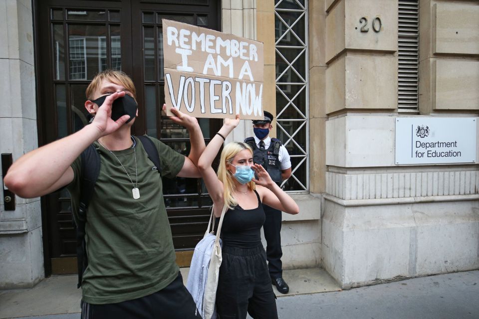 A protester carries a sign reminding Downing Street she is eligible to vote 