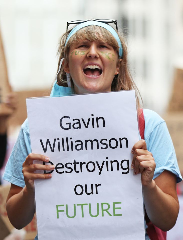 A protester holds a placard slamming the Education Secretary