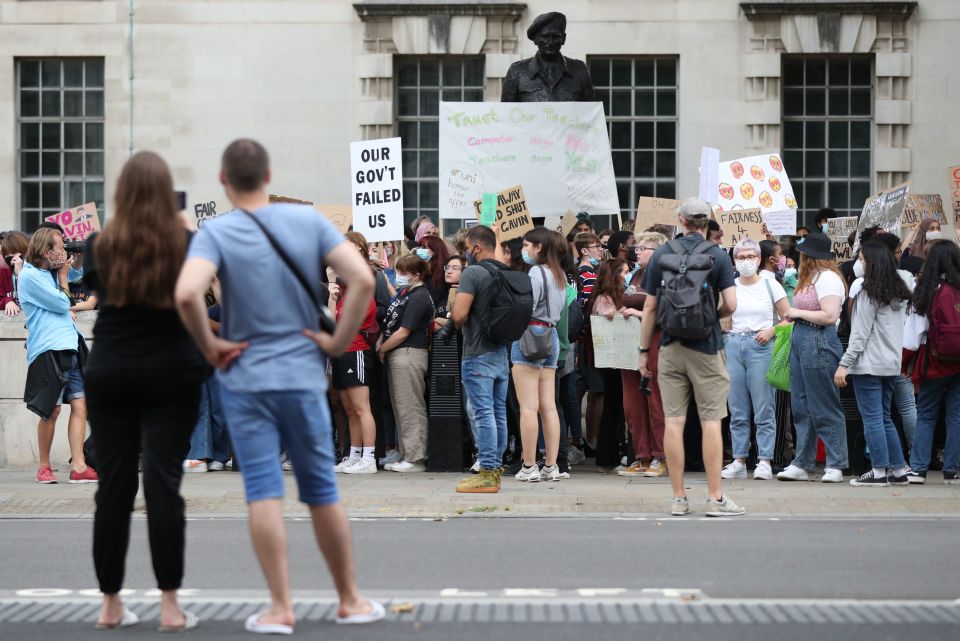 Bystanders watch the protesters at the Department of Education earlier today