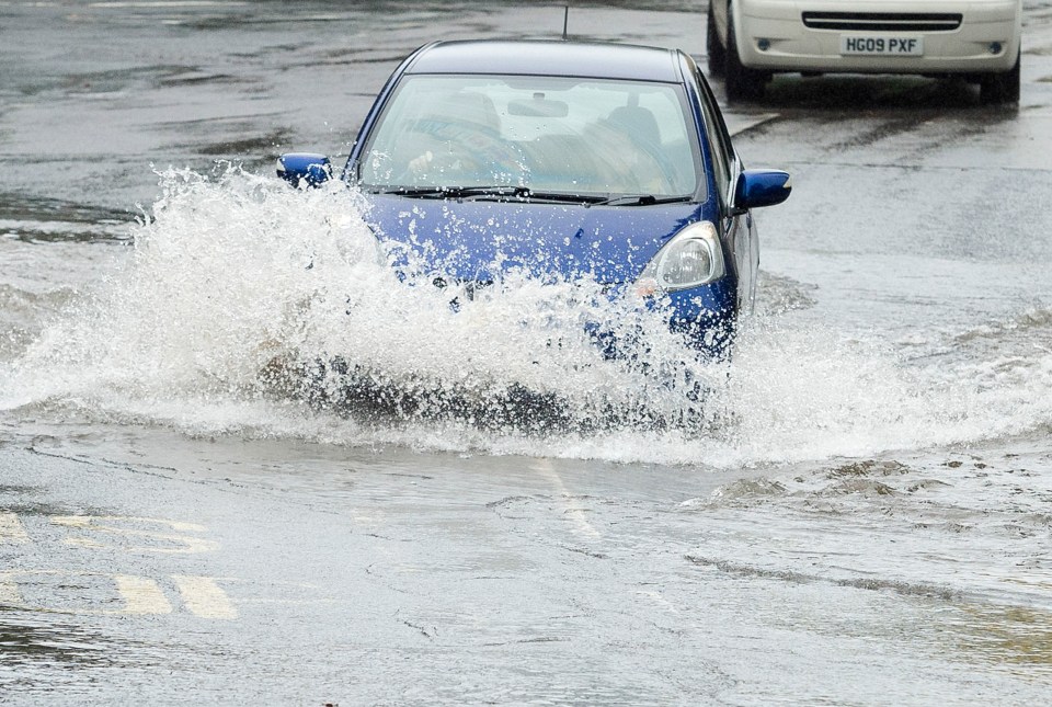 Traffic continues through a flooded road on Henbury Road, Bristol