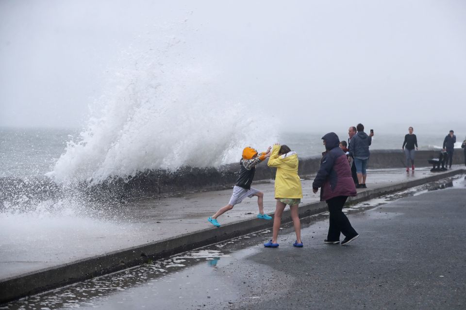 People are hit by waves from gale-force winds in Cork, Ireland