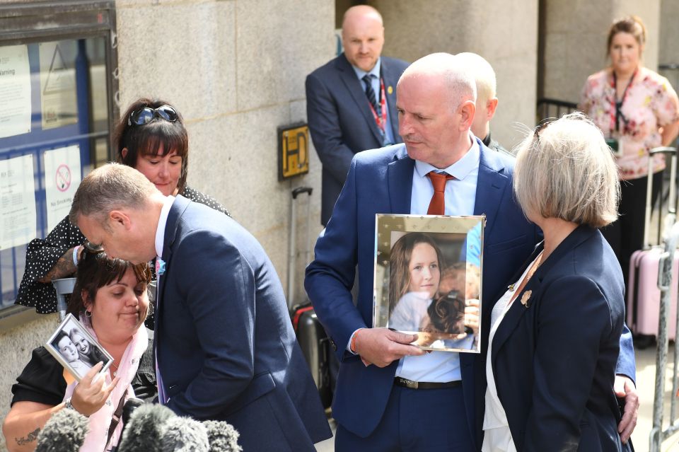 Families of the victims clutch photographs outside the Old Bailey