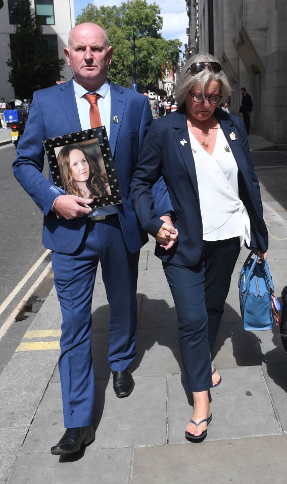 The parents of 15-year-old Megan Hurley carry a photo of their daughter today as Abedi was jailed