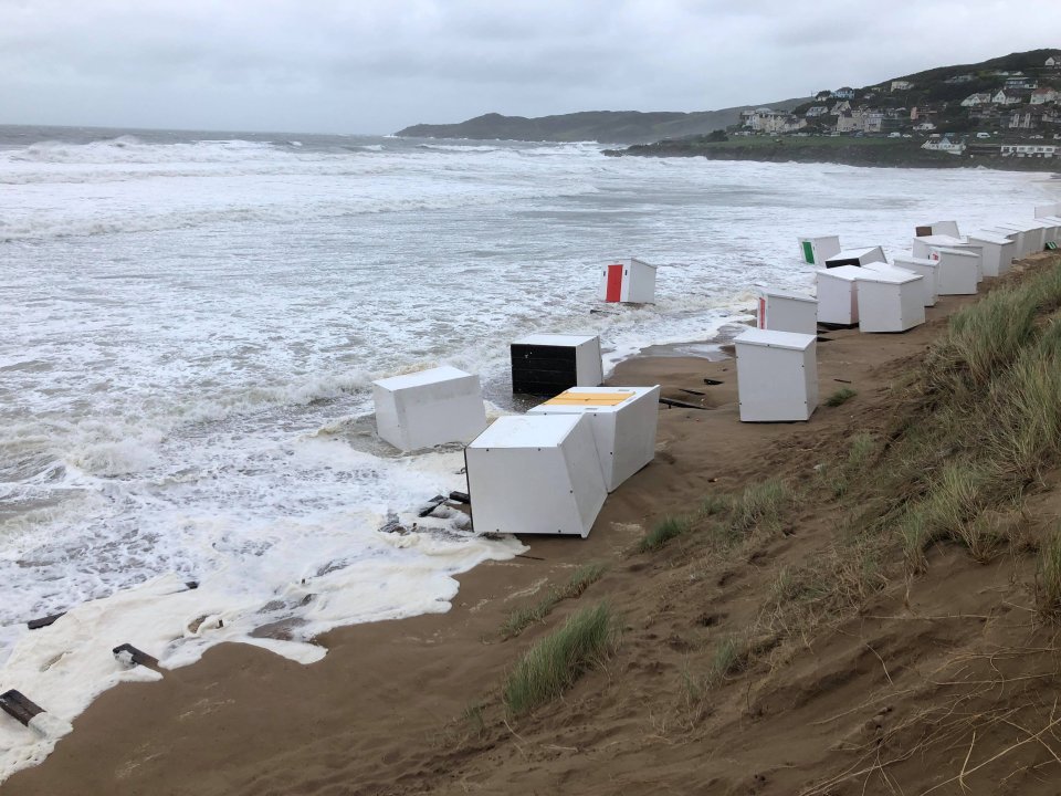 Beach huts scattered across Woolacoombe Beach as high tides carried them away