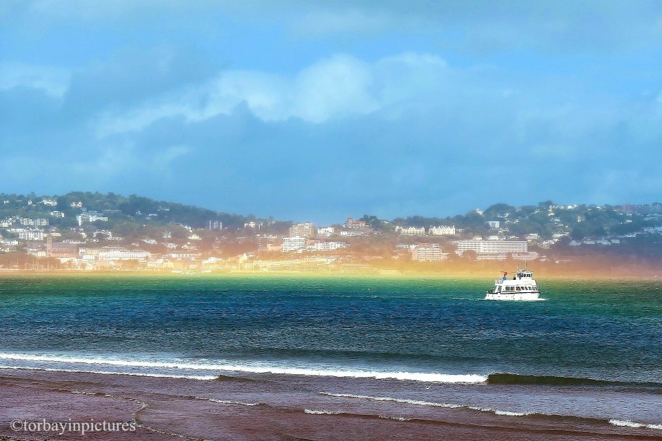 A photographer standing on the beach at Paignton in Devon captured these stunning photos of a rare 'flat rainbow'