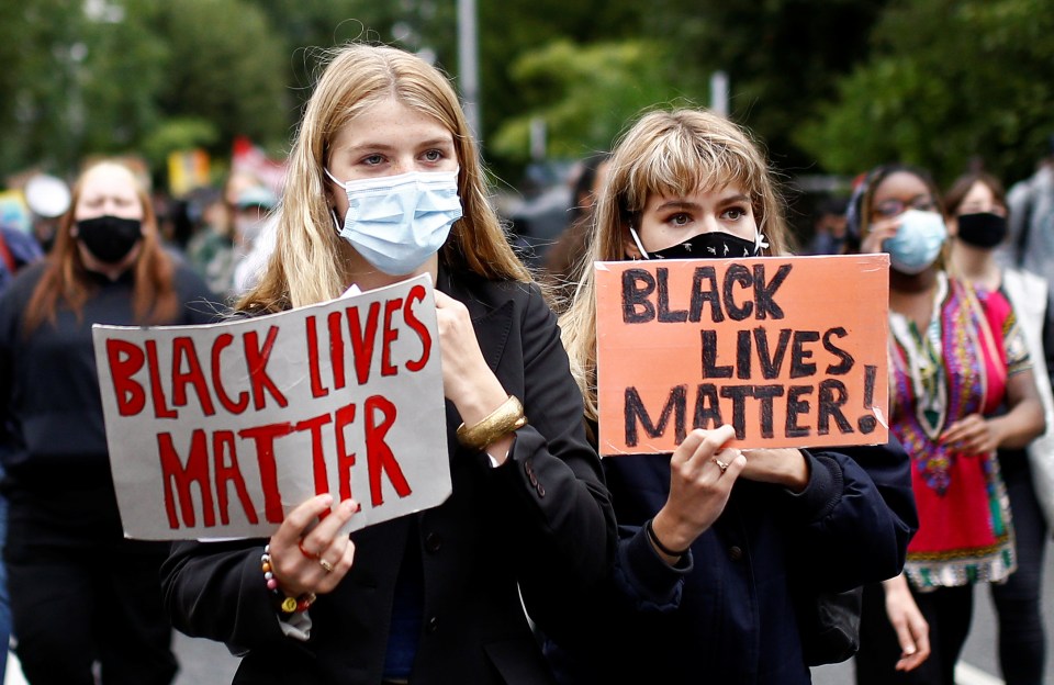 Two demonstrators holding up ‘Black Lives Matter’ signs