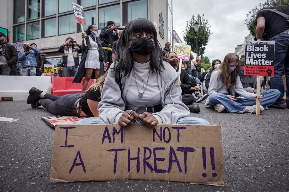 One protester holds a sign saying ‘I am not a threat’