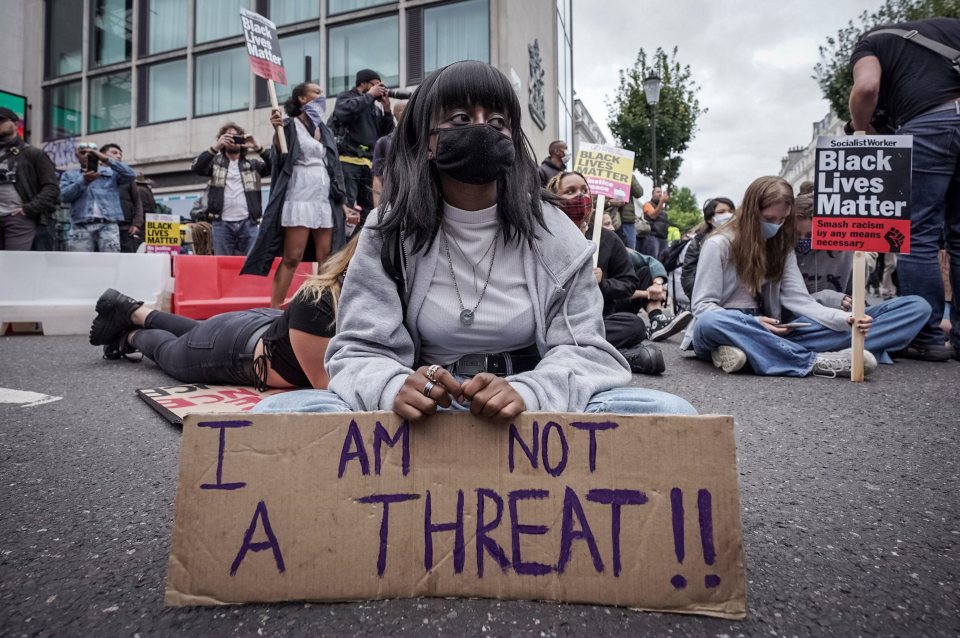 One protester holds a sign saying 'I am not a threat'