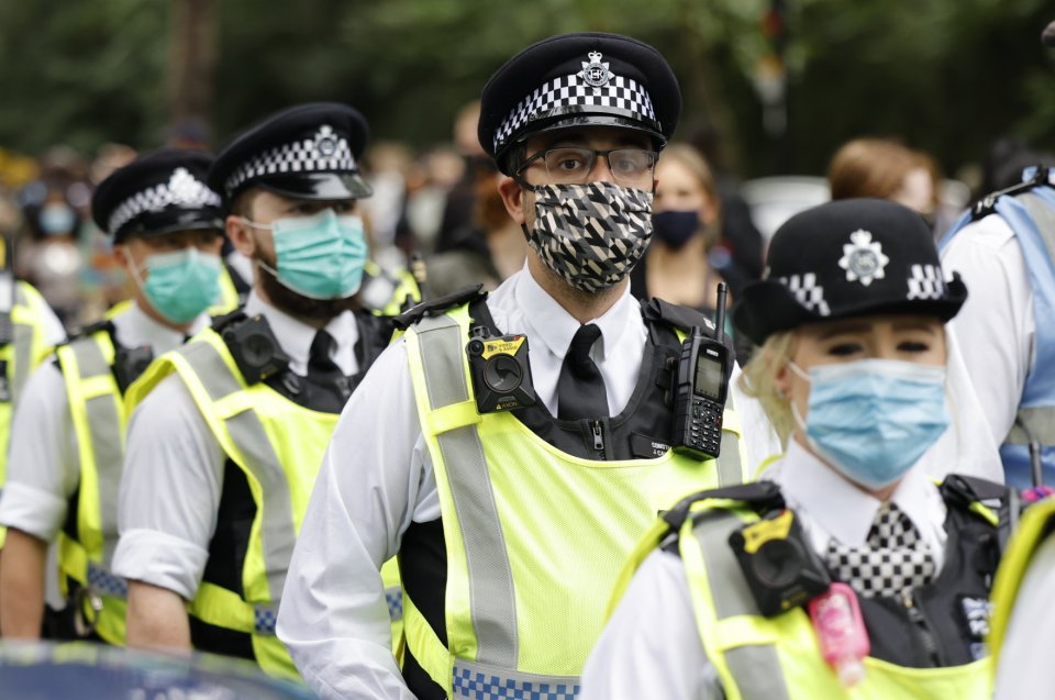 Police wear face masks during the Million People March from Notting Hill to Hyde Park in London