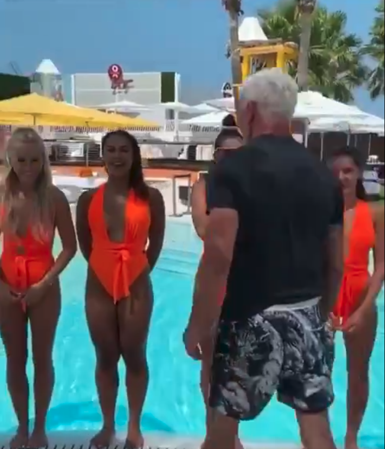 The young orange-swimwear clad staff wait in front of the pool