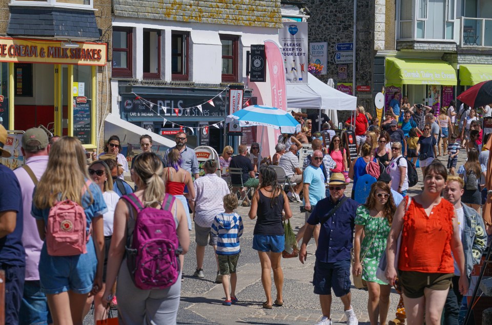 Tourists walk the narrow streets in St Ives