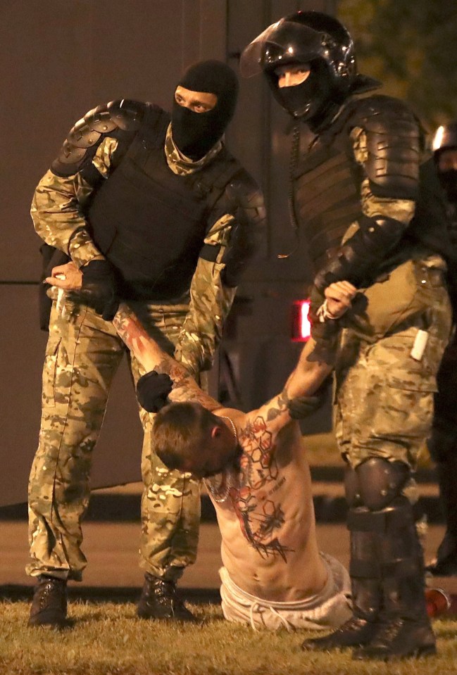 A shirtless protester is held by police amid violent scenes in Belarus 