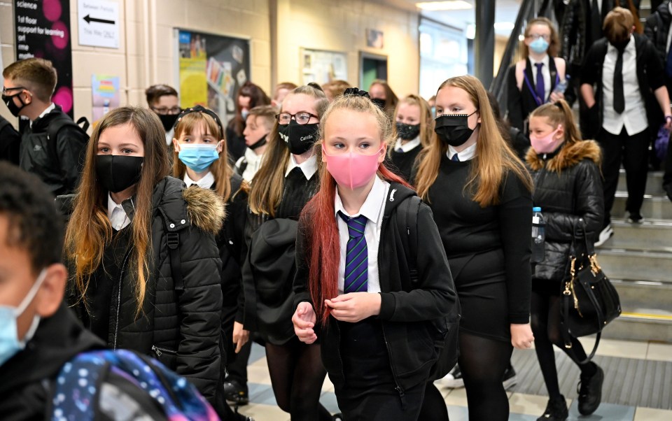 A group of secondary students stay safe with masks in the busy corridor