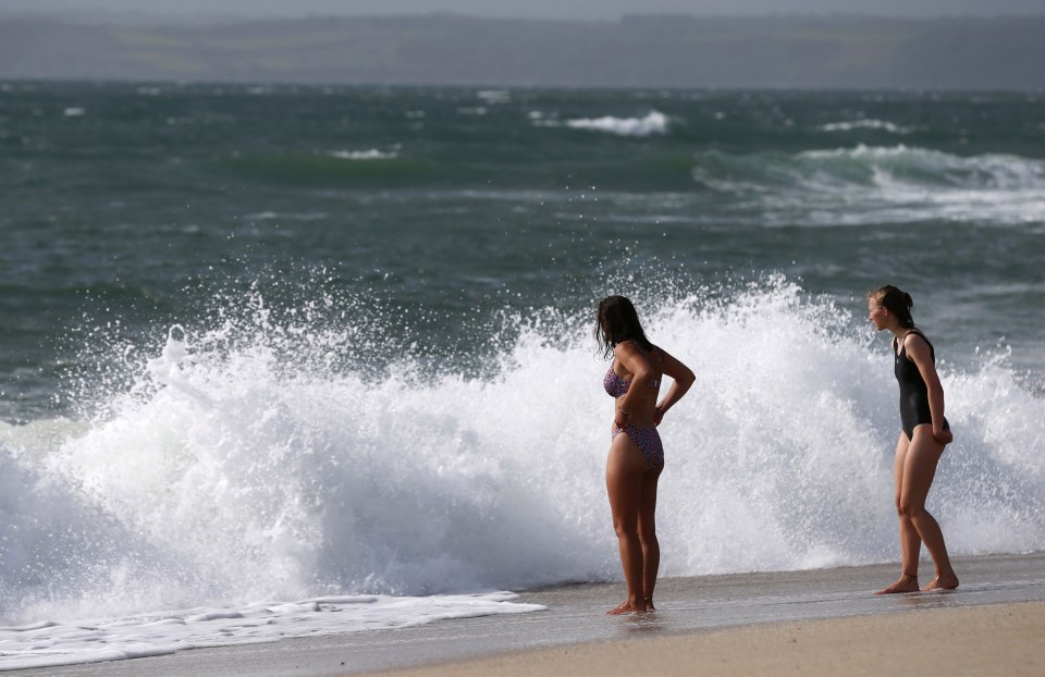 People swim in the sea as Storm Ellen lashes the south west coast 