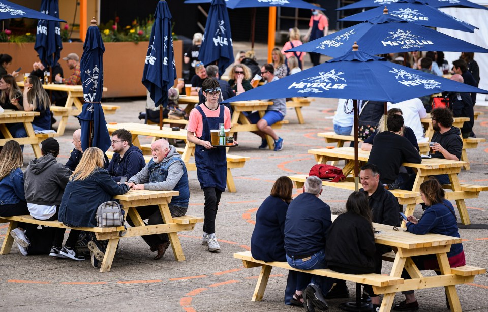 Socially distanced boozers enjoy a pint in a beer garden