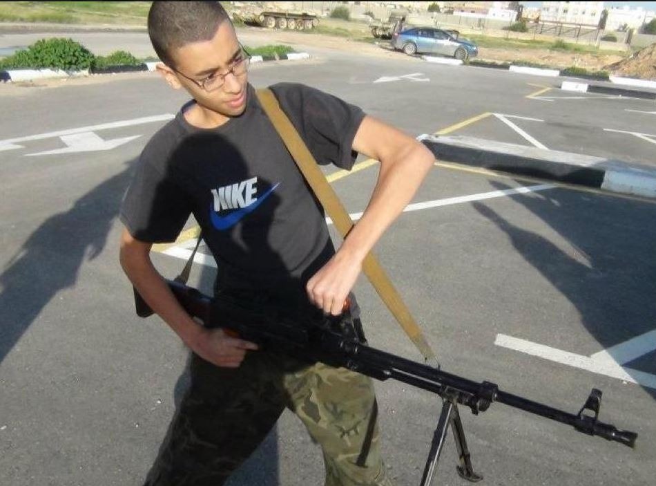 Previous pictures also showed a teenage Hashem grimacing as he posed with a large machine gun wearing the same Nike t-shirt