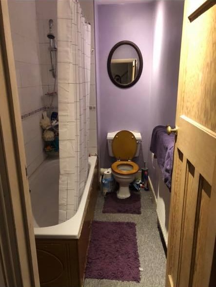 The bathroom featured bright purple hues and outdated finishes