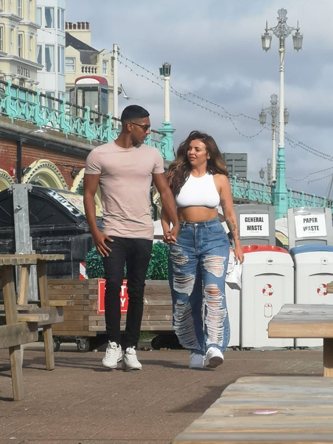 The couple talking a walk hand-in-hand along the Brighton seafront