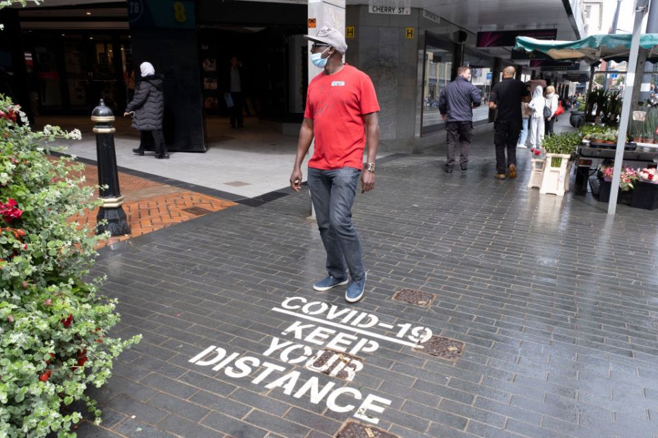 A man wears a mask as he walks through the city