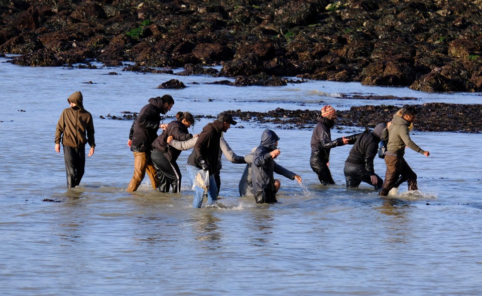 Images show a group wading the water after crossing the English Channel