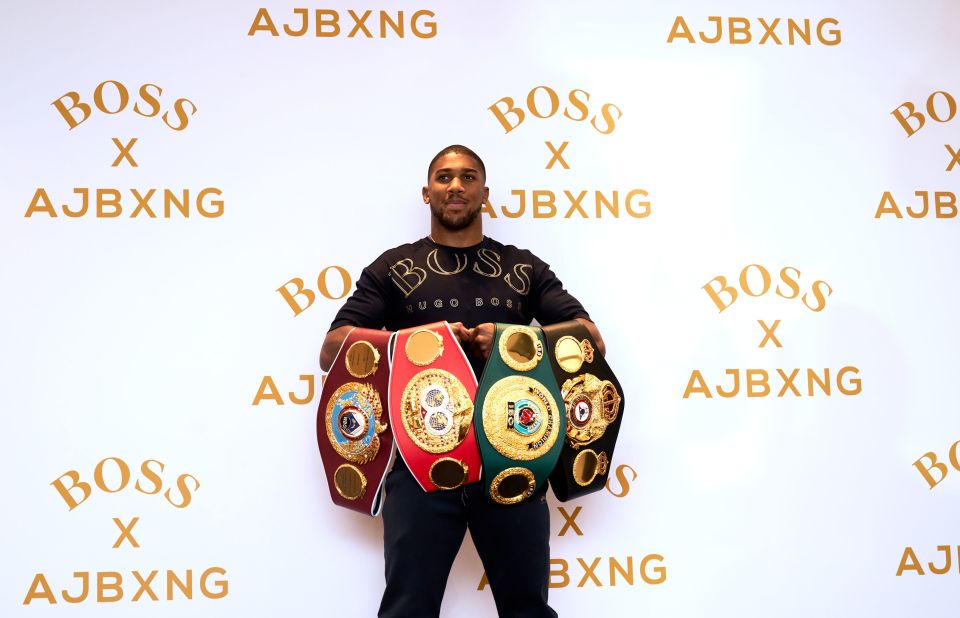 Joshua with his WBO, IBF, IBO and WBA belts 