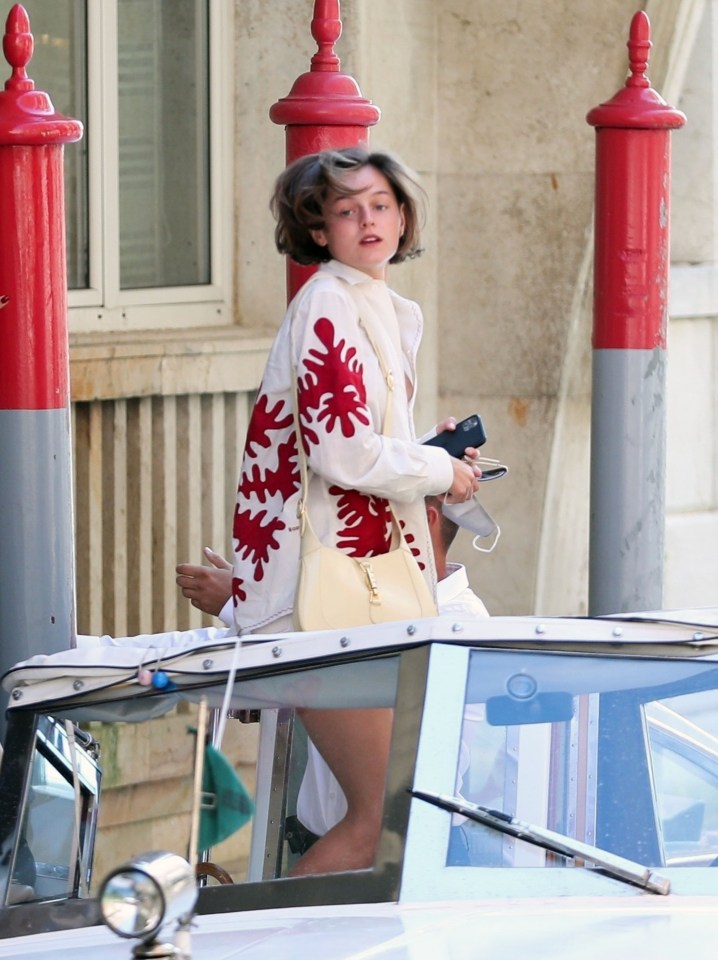 Emma Corrin wore a bold red and cream coat while out in Venice