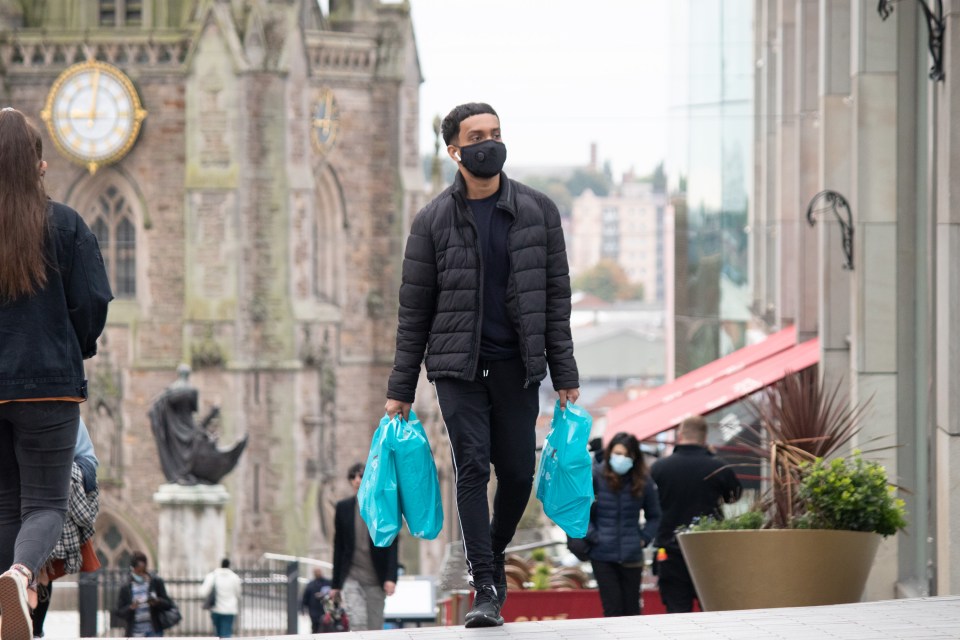 Shoppers wearing masks walk through Birmingham city centre this morning