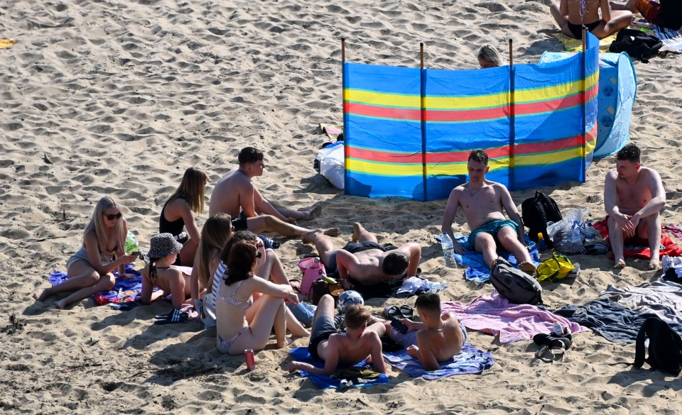 Others soaked up the sun on the beach as they flouted the new measures