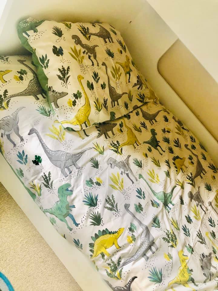 The bed has a dinosaur-themed duvet cover which she picked up from Aldi