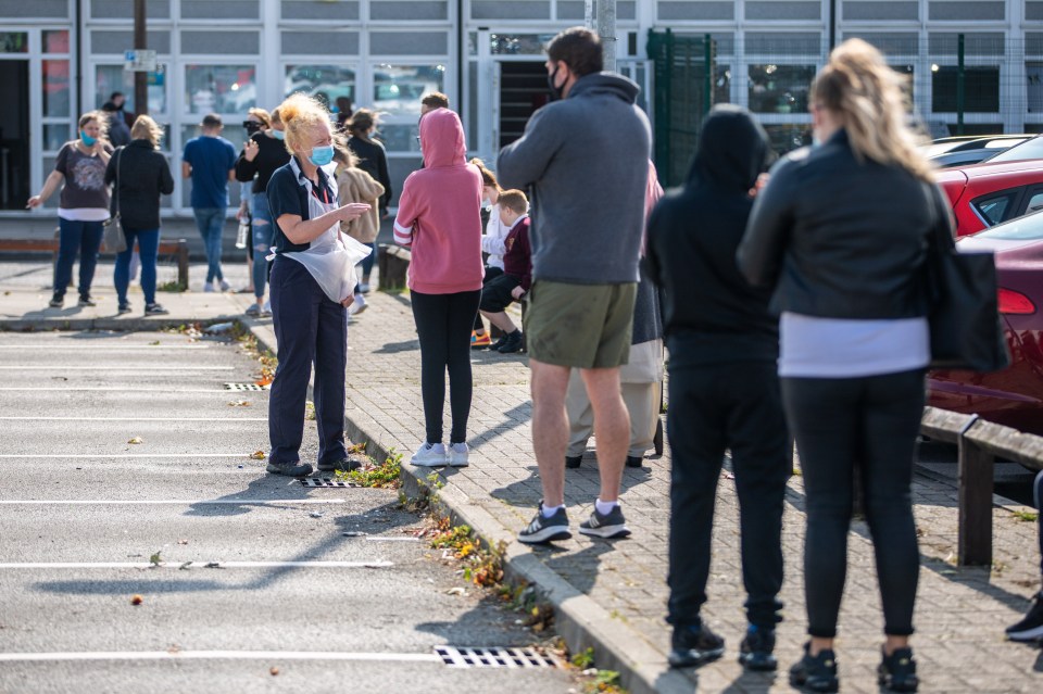 People queue for a walk-in coronavirus test at a newly opened site in Bury, Greater Manchester