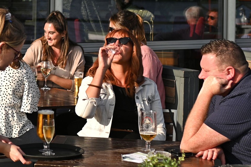 Drinkers enjoy a glass of wine and a pint in the sunshine yesterday