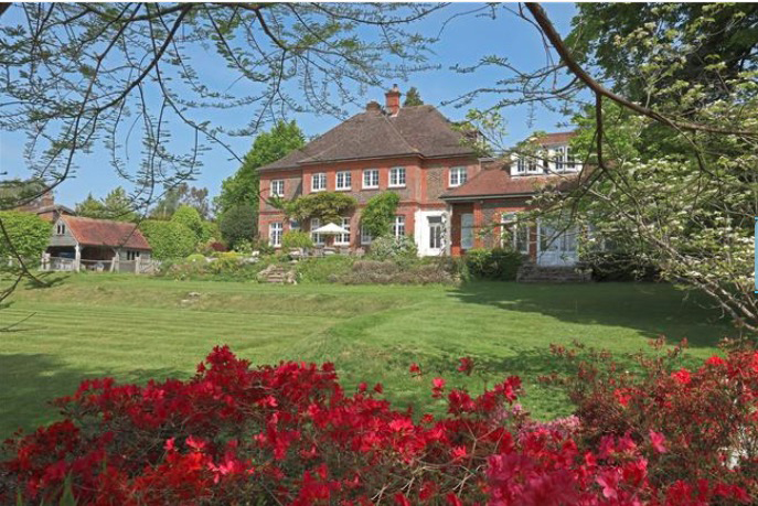 The house is surrounded by acres of land and beautiful greenery