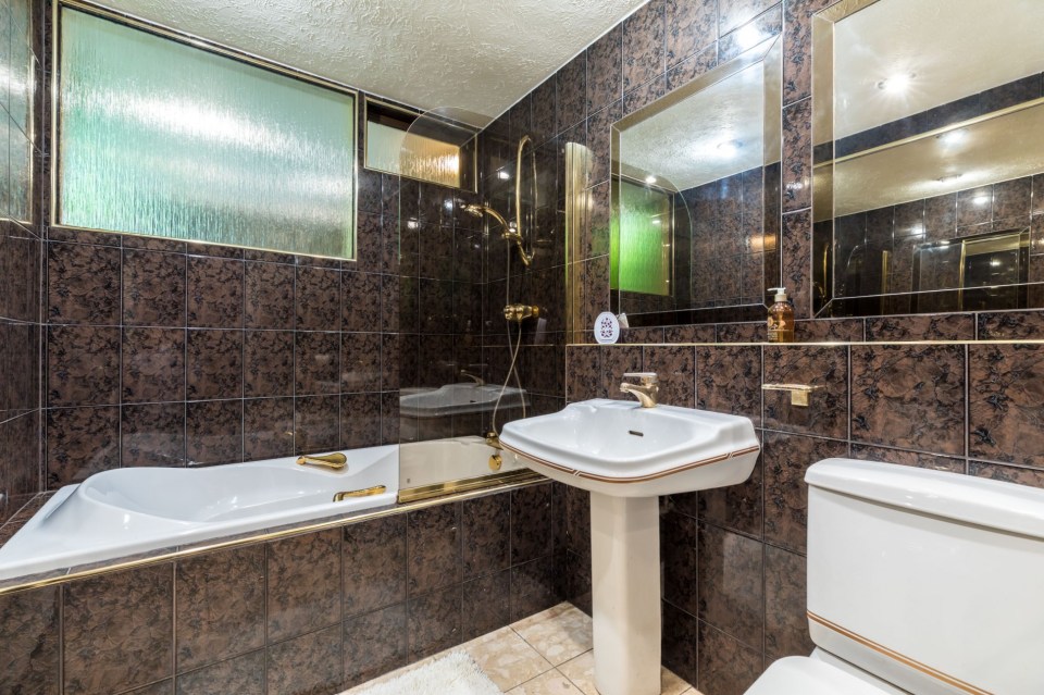 The three-bedroom house has a gold and brown bathroom