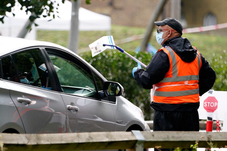 A member of staff at a central London carries out a coronavirus test at a centre