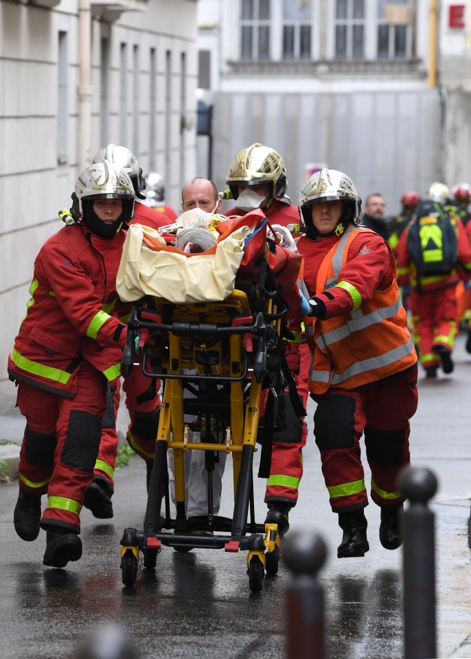 Emergency workers rush a victim on a stretcher to an ambulance