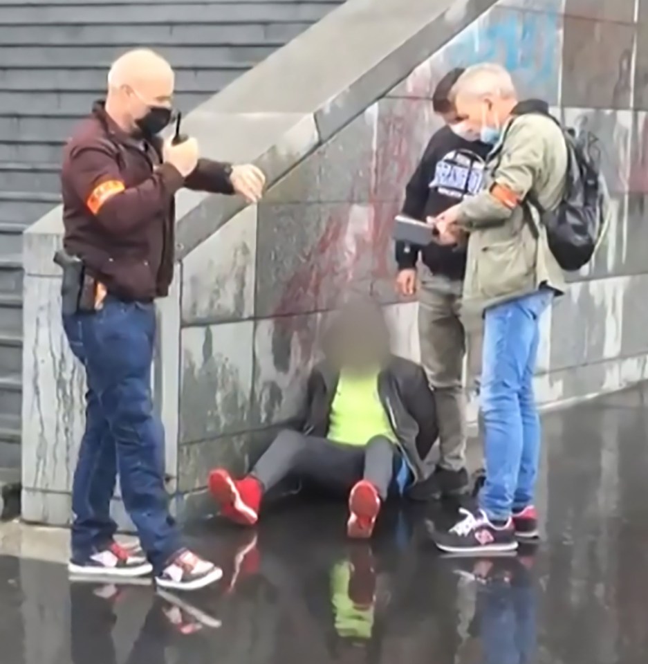 A suspect being detained by cops some 800 metres from the scene