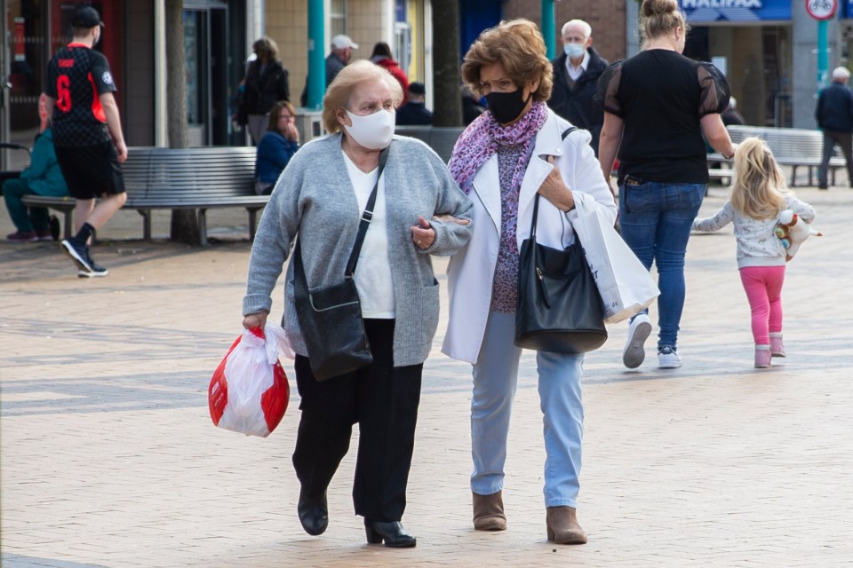 Two women walk down the high street of Huyton in Knowsley, Merseyside