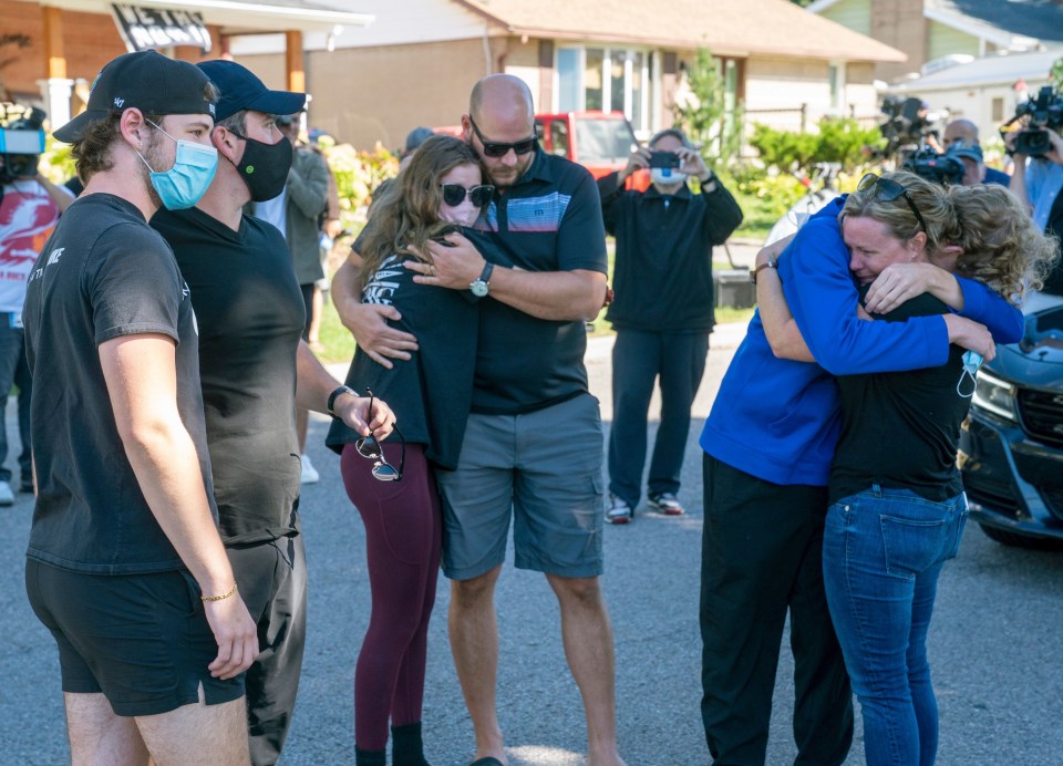 A group gathered outside the home on Parklane Avenue in Oshawa, Ont