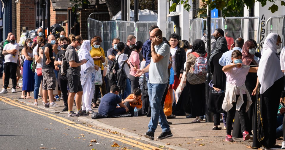 Queues stretch along the pavement at a walk-in testing centre in London