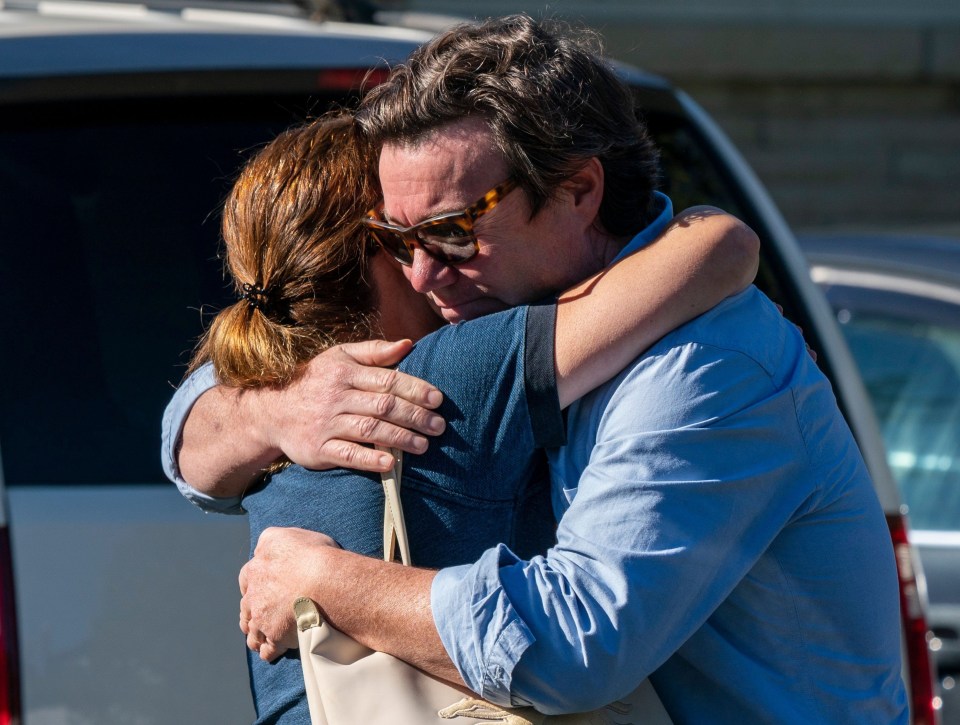 Friends of the victims react after laying flowers at the scene